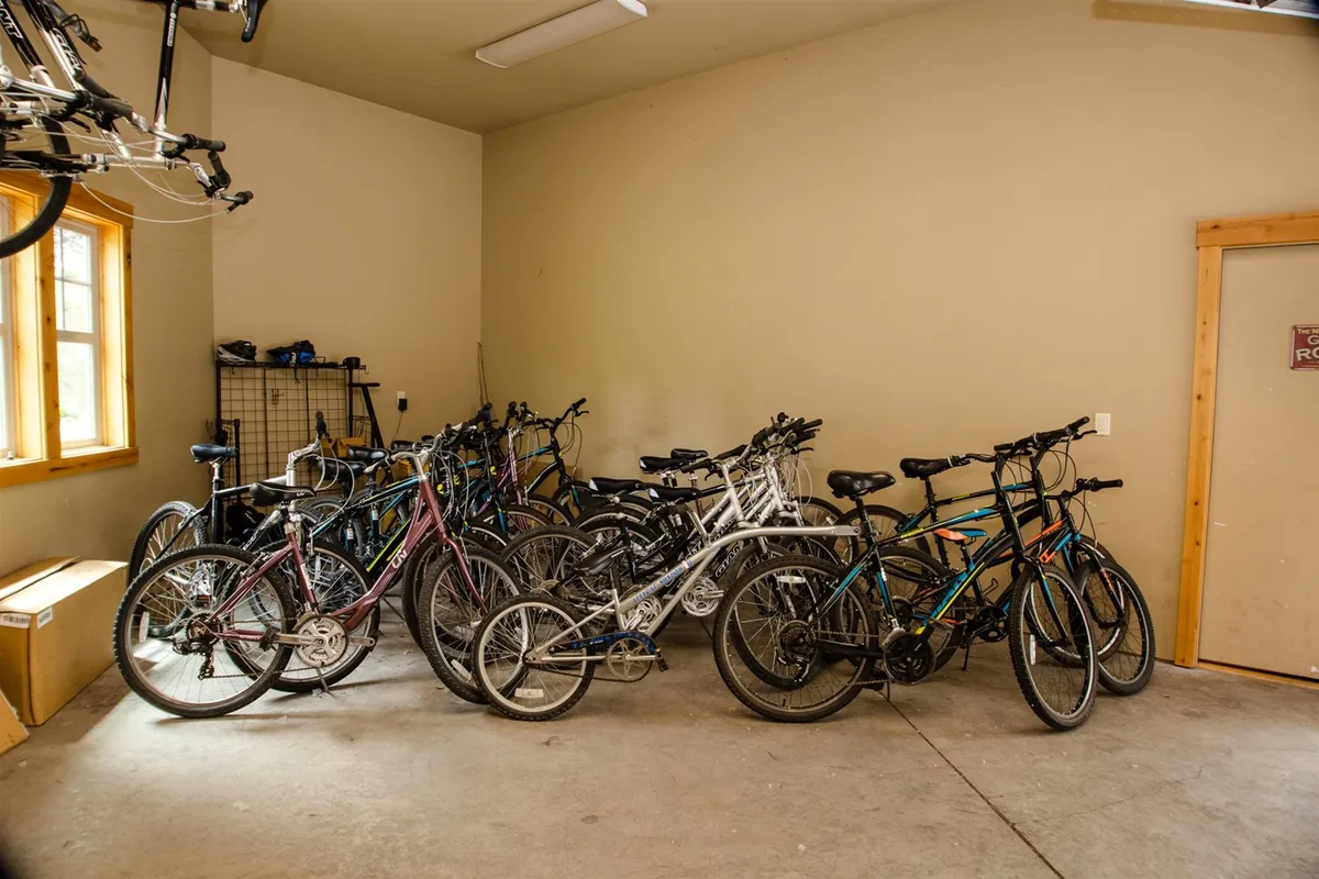 This image features a collection of bicycles neatly stored in a bright, organized area with a window, referencing the availability of adult and family bikes for guests to use during their stay.